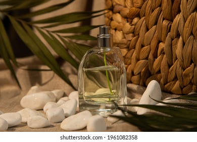 Perfume Glass Bottle For Men Or Women On Natural Linen Fabric Among Stones And Tropical Leaves, Fragrance Concept, Close-up Photo