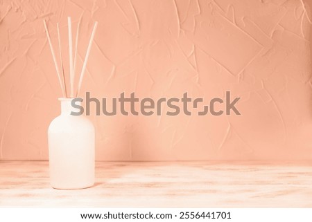 Perfume for home. Aromatic reed diffuser in on Mocha brown background. Concept of peace, relaxation and enjoyment. Demonstrating color of 2025 year