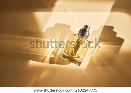 Perfume on a beige background in the rays of bright sun with beautiful highlights.