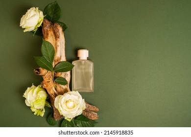 Perfume on tree bark with flowers roses on green background with copy space. concept of freshness and naturalness. the aroma of wood