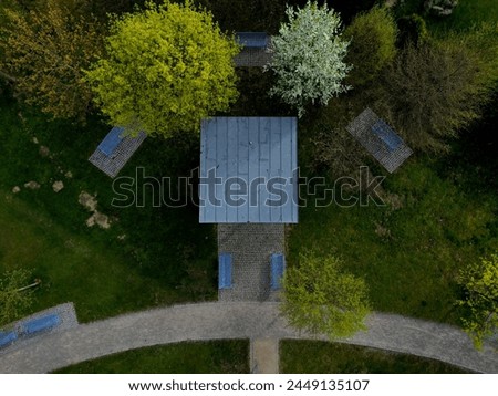 pergola of metal galvanized construction with blue planks in the side. under the shades there is a bench. city ​​shelter for lectures and concerts. public gazebo modern look
