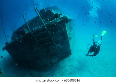 Perhentian Island, Malaysia - June 16, 2017: A scuba diver swimming next to a shipwreck at Perhentian Island. A shipwreck attracts marine lives and is popular dive spot for a diver to explore.