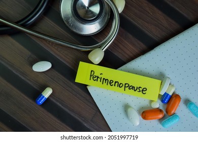 Perimenopause write on sticky notes isolated on Wooden Table.