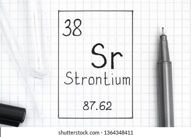 The Periodic table of elements. Handwriting chemical element Strontium Sr with black pen, test tube and pipette. Close-up.