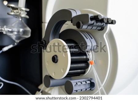 Peristaltic pump with plastic tubes and rollers moving.
