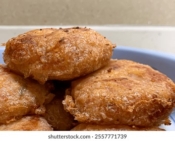 Perkedel kentang is Indonesian fried potato cakes made from a mixture of mashed potatoes, fried onions, green onions, and coated with egg before frying. - Powered by Shutterstock