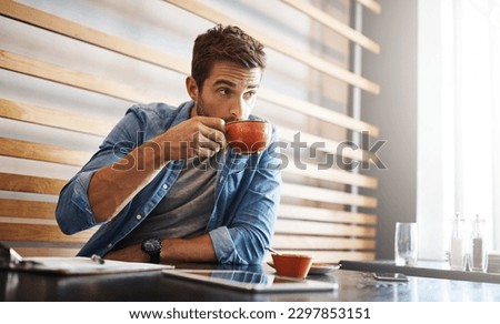 The perks of being the owner, free coffee. a handsome young man drinking coffee while working in a coffee shop.