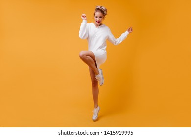 Perky, full of strength lady in good mood is having fun on isolated background. Blonde with curls happily jumping - Shutterstock ID 1415919995