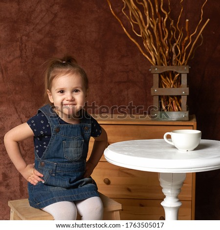 Perky girl at the tea table, square image.