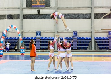 Perm, Russia - March 28, 2015. Championship Perm Krai On Cheerleading. Girl In  Pink  And White Suit  Fall Diwn  In Group Stunt