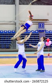 Perm, Russia - March 28, 2015. Championship Perm Krai On Cheerleading. Girl Jumps To Screw Men Hands In  Pair Stunt