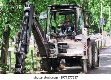 Perm, Russia - May 18, 2021: Backhoe Driver Dozed Off In The Cab During Lunch Break