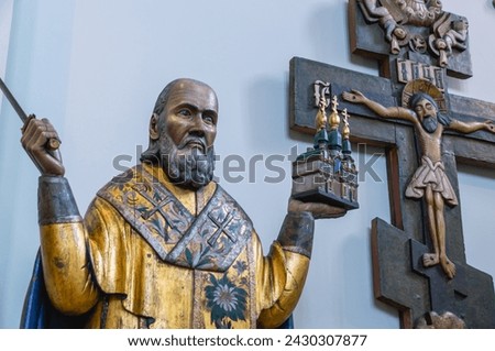 Perm wooden sculpture. A saint carved out of wood. Ancient sculptures in the church. The figure of a priest, carved from wood. Ancient masterpieces of wooden architecture. Religion and faith.