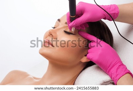 Permanent make-up for eyebrows of beautiful woman in beauty salon. Closeup beautician doing eyebrows tattooing. arrows on the eyes