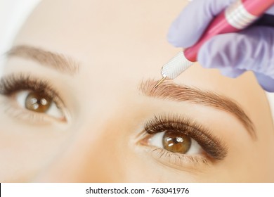 Permanent Makeup For Eyebrows. Microblading brow.  Beautician Doing Eyebrow Tattooing For Female Face. Beautiful young girl in a beauty salon.