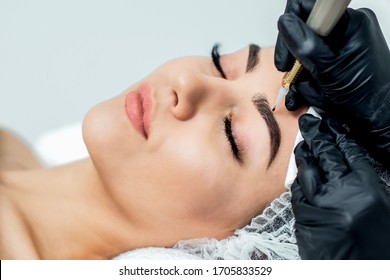 Permanent makeup on eyebrows by professional cosmetologist.