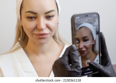 Permanent Makeup. Tattoo Artist Photographs A Client's Lips On His Phone