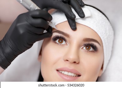 Permanent Makeup. Permanent Tattooing Of Eyebrows. Cosmetologist Applying Permanent Make Up On Eyebrows- Eyebrow Tattoo