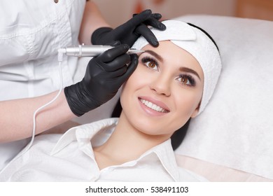 Permanent makeup. Permanent tattooing of eyebrows. Cosmetologist applying permanent make up on eyebrows- eyebrow tattoo