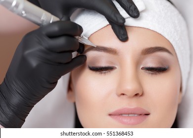 Dauerschminke. Dauertätowierung der Augenbrauen. Kosmetologe, die auf Augenbrauen fest auftragen - Augenbrauentätowierung
