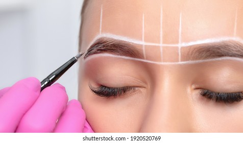 permanent makeup tattoo.Make-up artist makes markings with white paste for eyebrow tattooing. Professional makeup and skin care cosmetology.