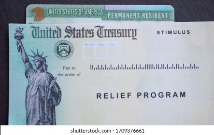 Permanent Resident Card Of United States Of America Next To The Stimulus Check Relief Program. Benefits For Green Card Holders Concept. 