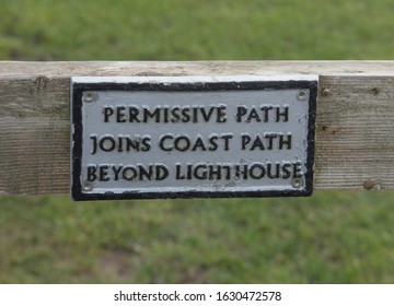 "Permissive Path Joins Coast Path Beyond Lighthouse" Sign Attached to a Wooden Gate at Lizard Point on the South West Coast path in Rural Cornwall, England, UK
