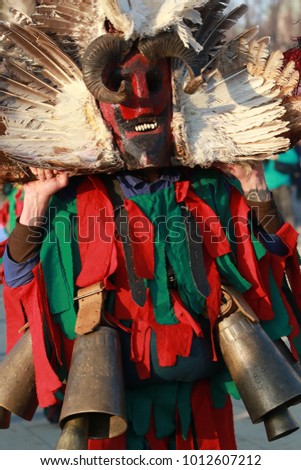 Pernik, Bulgaria - January 28, 2018: People with mask called Kukeri dance and perform to scare the evil spirits at the International Festival of Masquerade Games Surva in town Pernik, Bulgaria.