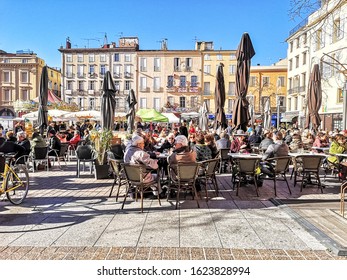 PERPIGNAN, FRANCE - JANUARY 10, 2020: People Enjoying The Winter Sunshine At The Outdoor Restaurants In Place De Republique, Perpignan, France