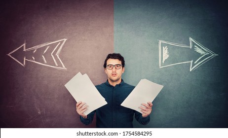 Perplexed Businessman Has To Choose As Holds Different Paper Documents In Both Hands. Selecting The Correct Financial Report, Arrows Shows Left And Right Sides. Difficult Decision, Doubt Concept.