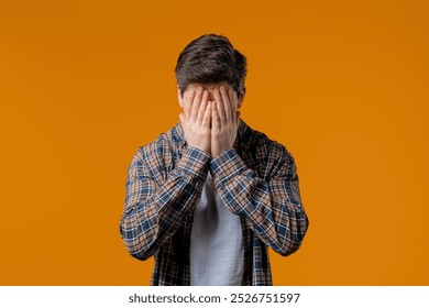 Perplexed man doing panic despair gesture, like no, I forgot. Disappointed guy feeling sorrow, regret, drama, failure, problems on yellow background. High quality