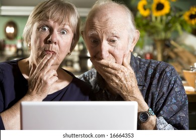 Perplexed Senior Couple in their Dining Room with a Laptop Computer