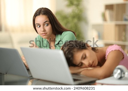 Perplexed student looking at her classmate sleeping at home