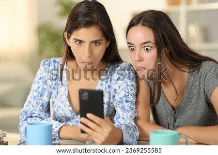 Perplexed women cheking cell phone content sititng at home