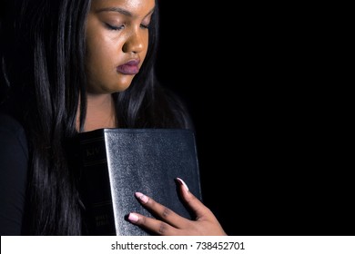 Persecuted Young Girl Holding Her Bible in the Darkness