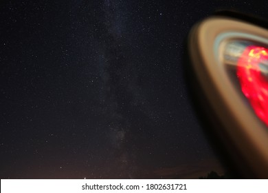 The Perseid Meteor Shower Can Be Seen In The Starry Sky. In The Foreground Is A Red Circle Of Light