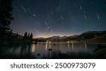 Perseids meteor Shower and the Milky Way silhouette in the foreground. Perseid Meteor Shower observation. Night sky nature summer landscape. Colorful shooting stars