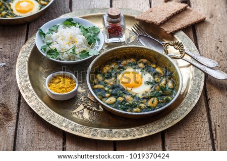 Persian breakfast with eggs, bean and dill in copper pan