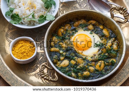 Persian breakfast with eggs, bean and dill in copper pan