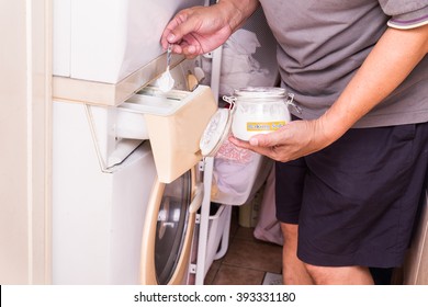 Person Adding Baking Soda Into Washing Machine To Wash Clothes For Brighter And Cleaner Finish