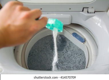 Person Adding Baking Soda Into Washing Machine To Wash Clothes For Brighter And Cleaner Finish