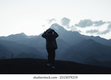 Person admiring mountain view at twilight
A person stands facing a distant mountain range at twilight, capturing a serene moment of reflection and connection with nature. - Powered by Shutterstock