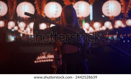 Person against big digital wall in studio. Woman silhouette with japanese sword katana acts in front of digital screen neon graphic visual background.