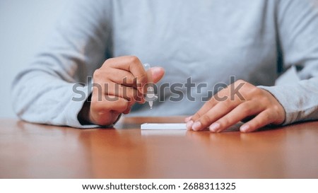 A person applies a testing solution in a lab setting showcasing a crucial health diagnostic process.