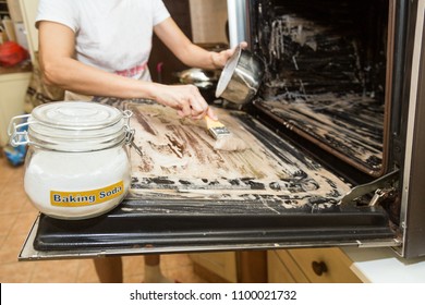 Person Applying Mixed Baking Soda Onto Surface Of Oven For Effective And Safe Cleaning