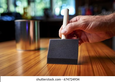 A Person Applying Varnish To A Wood Surface