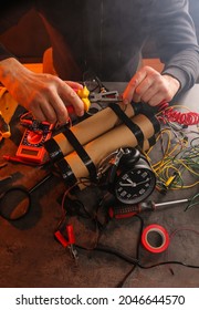 Person assembling an improvised explosive device with wires, alarm clock, and tools, terrorism and danger
