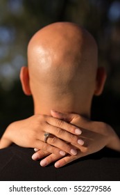 A Person With A Bold Head With Woman's Hands On His Neck