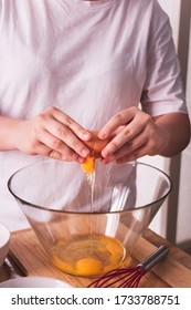 Person Breaking An Egg Into A Bowl