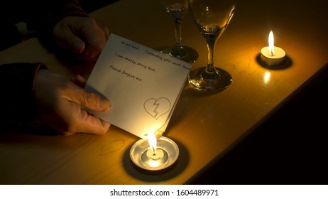 A Person Burning A Love Letter In The Fire Of A Candle. 
